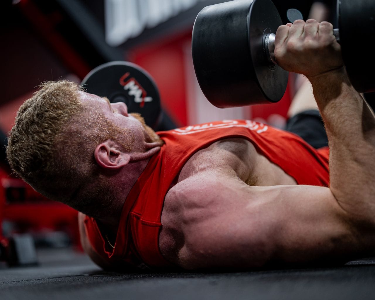 dumbbell floor press lying on gym floor