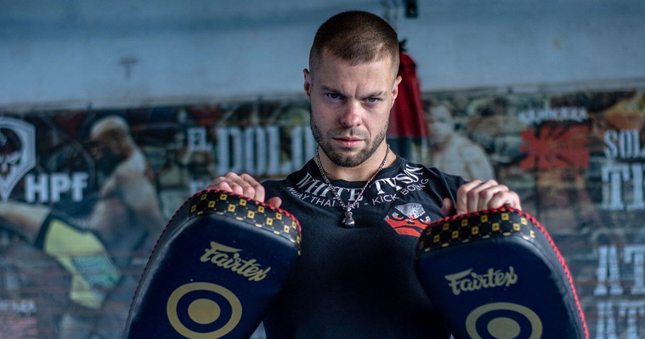 muay thai trainer holding thai pads in gym