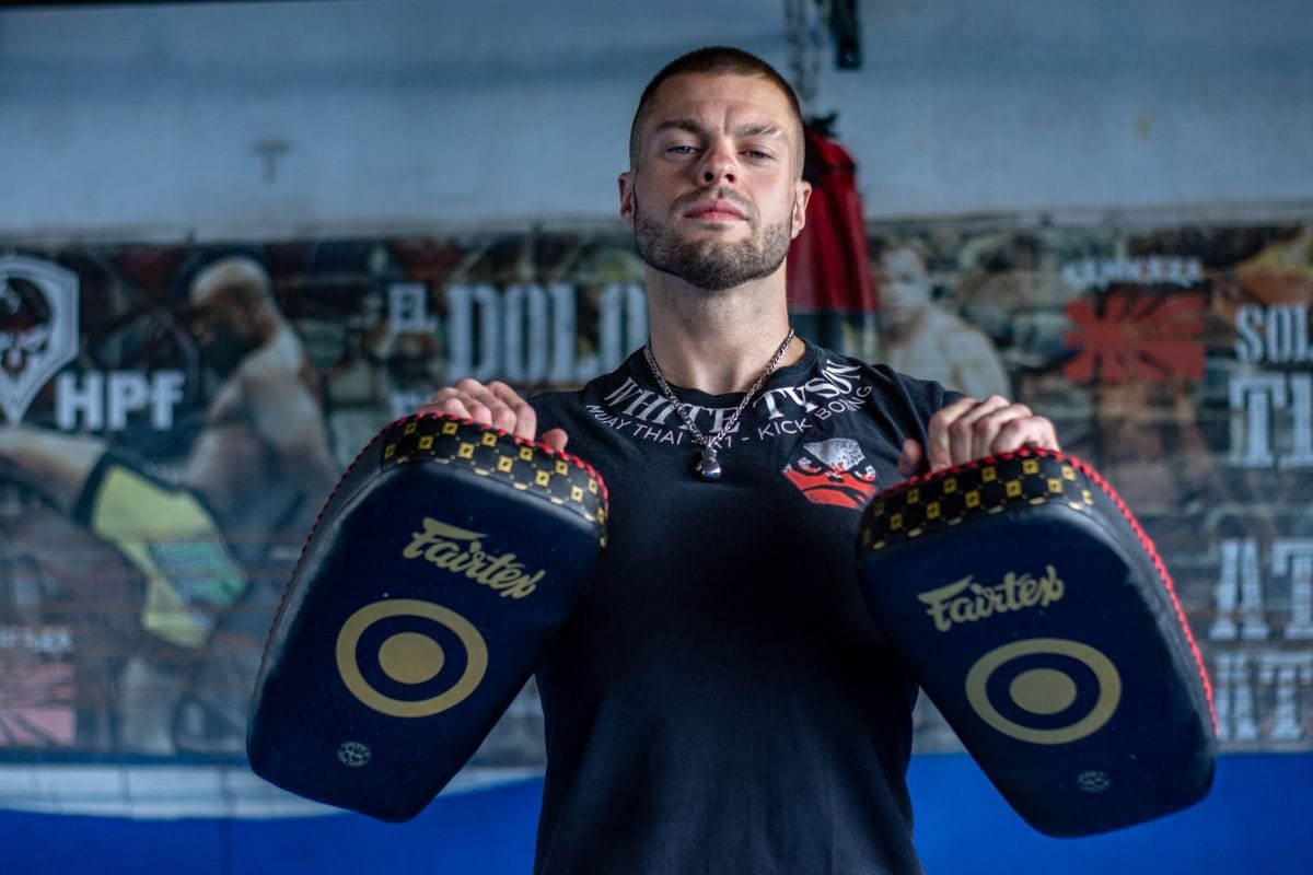 muay thai vs boxing training pads held by a boxer in the gym