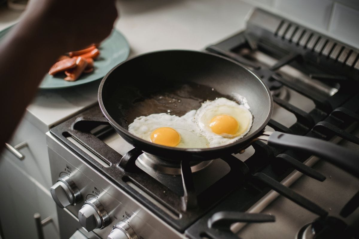Fried eggs cooking in a pan — protein content stays the same whatever the method