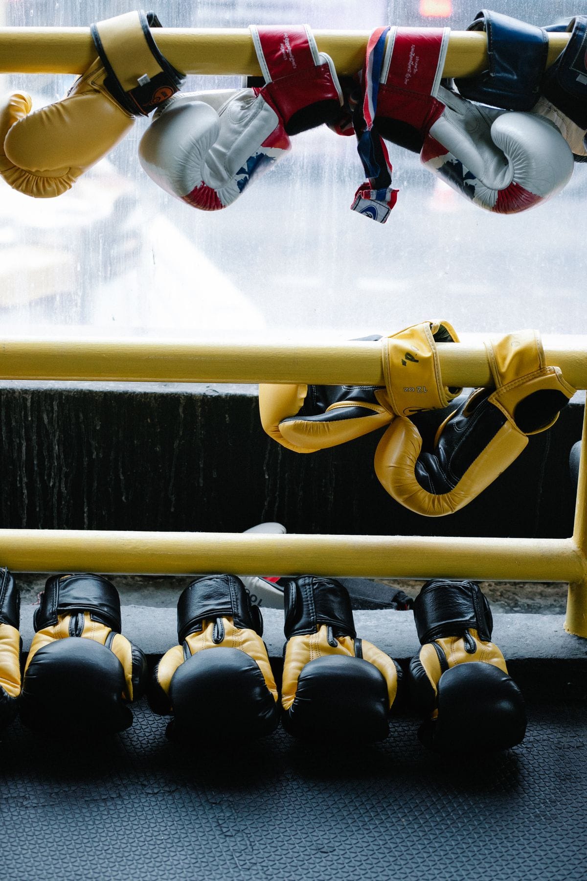 Boxing gloves Malaysia — coloured gloves hanging on gym railings